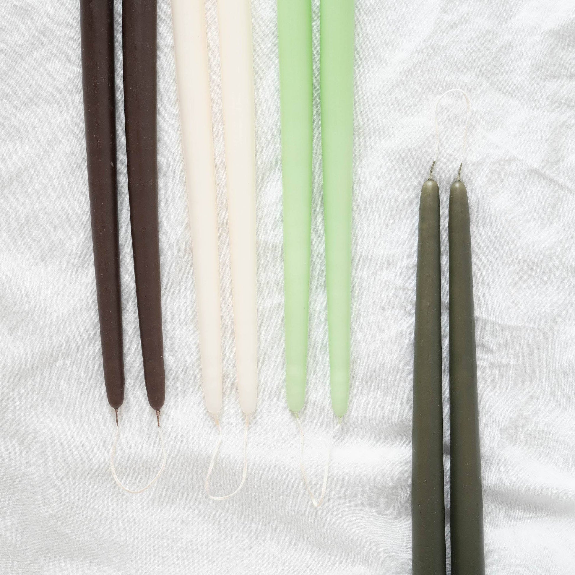 Hand-dipped taper candles pairs in various colors: brown, ivory, light green  and olive.