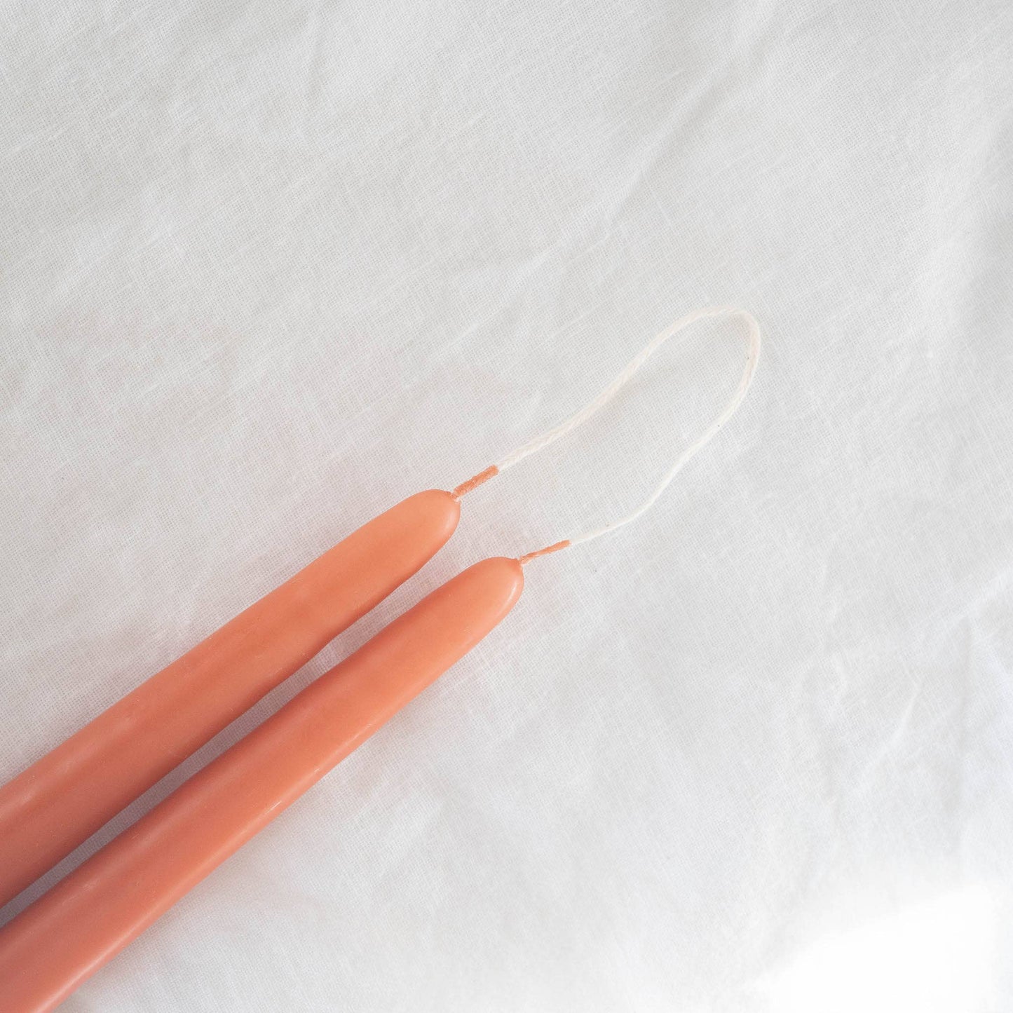 Close-up on a pair of hand-dipped terracotta taper candles