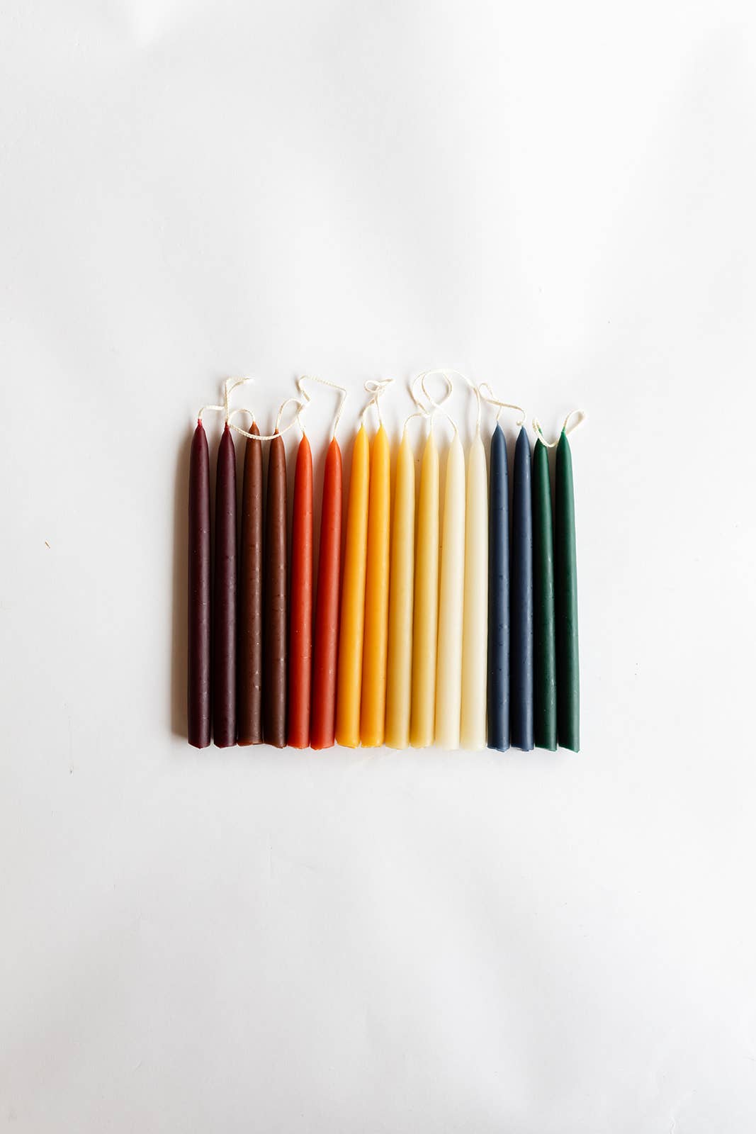 Set of colorful candles arranged in a row on a white background