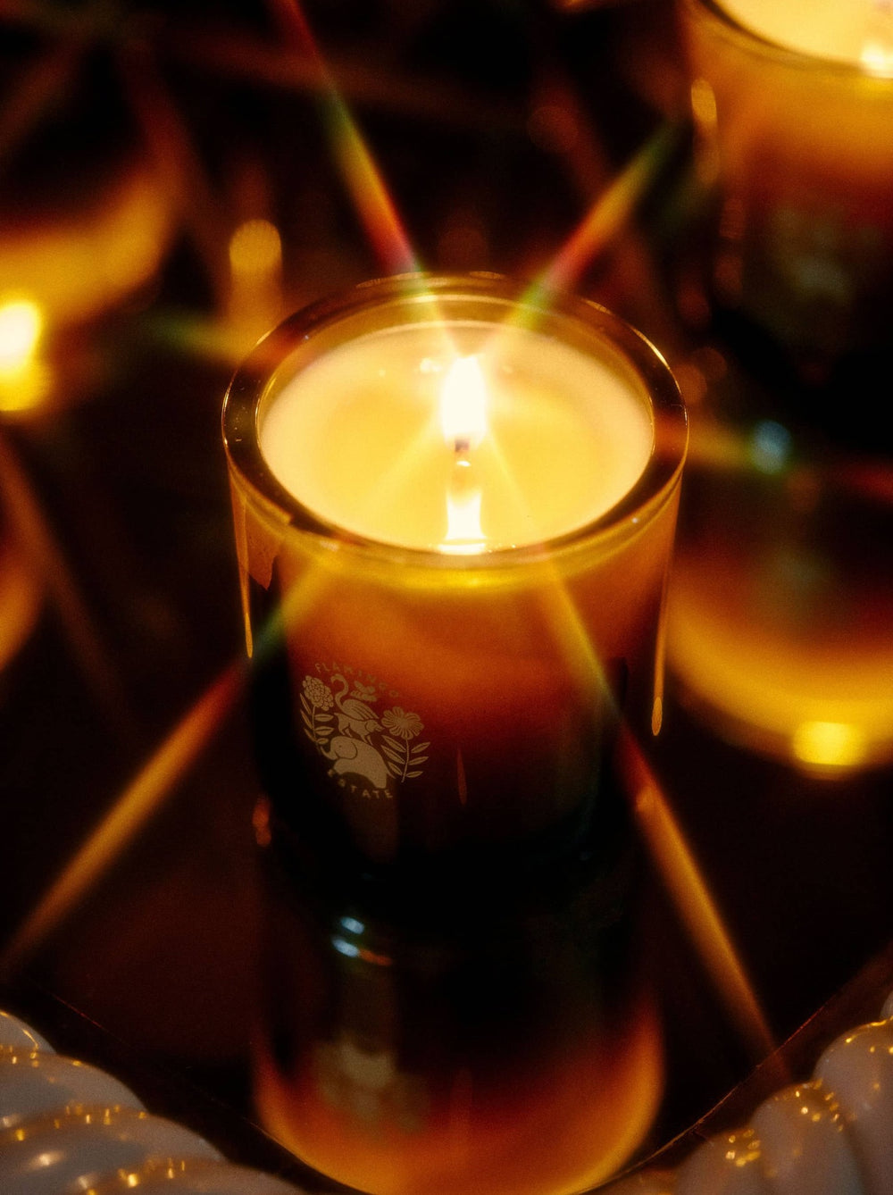 Candle with the flamingo estate logo in a dark setting