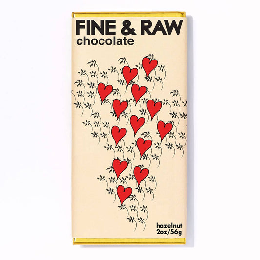A Valentines hazelnut butter dark chocolate bar with a design of red hearts and leaf patterns on it, from the brand 'Fine & Raw Chocolate'