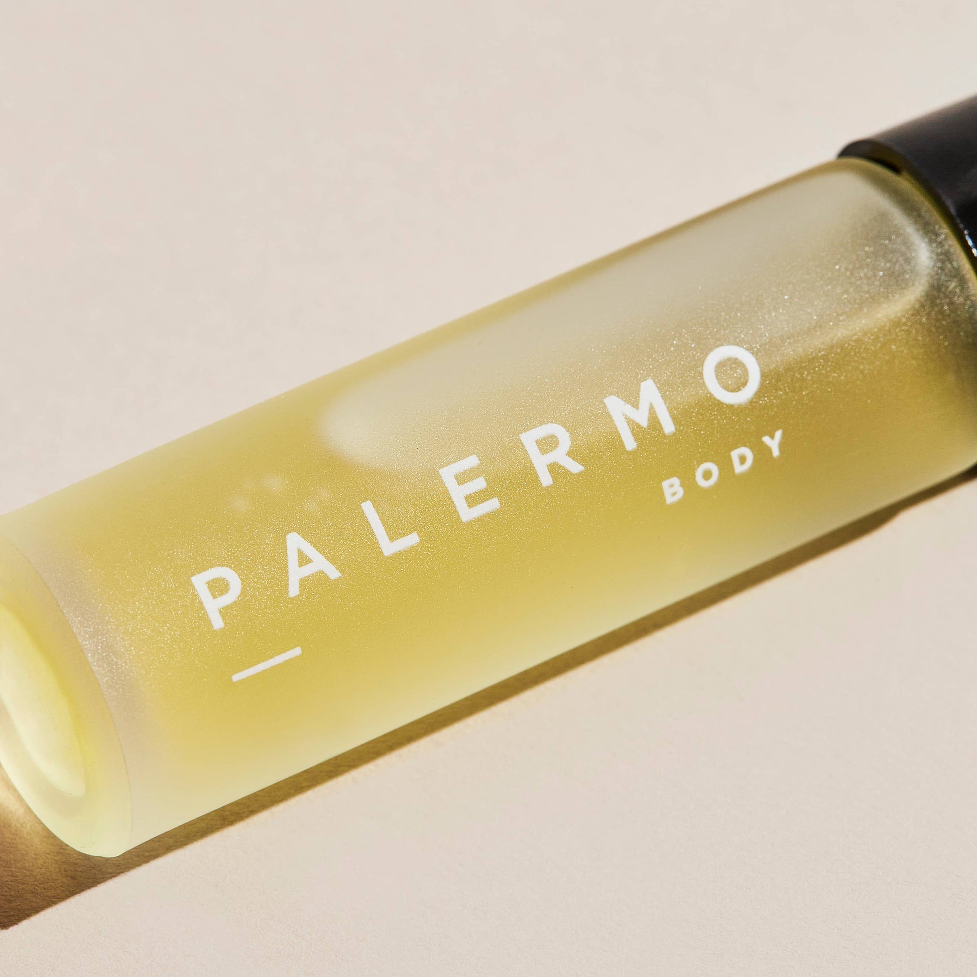 Bottle of 'Palermo Body' vitality aromatherapy oil, a floral essential oil roll-on, on a beige background