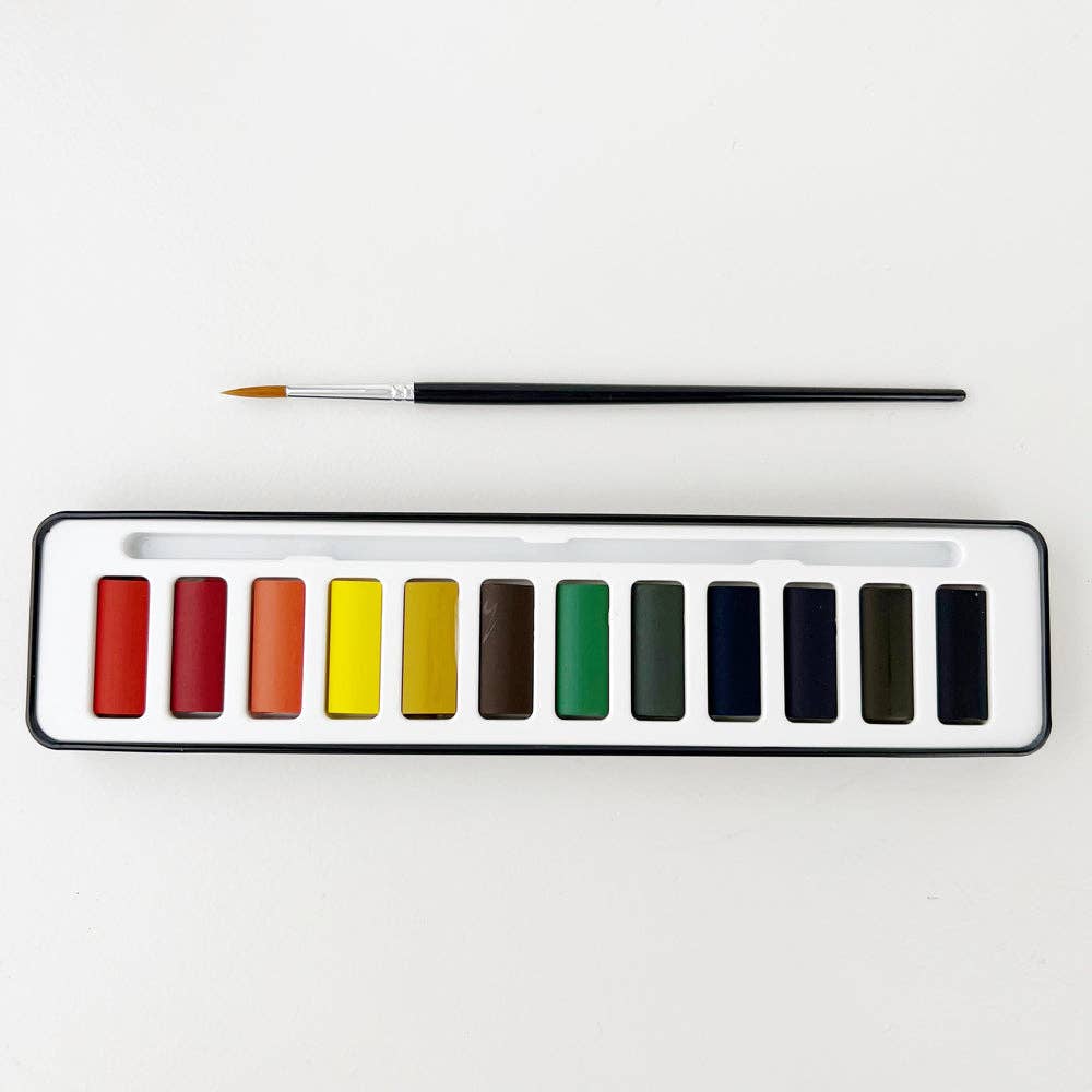 A watercolor paint set with 12 colors displayed in a black tin case alongside a round size 4 brush. Travel-ready size.
