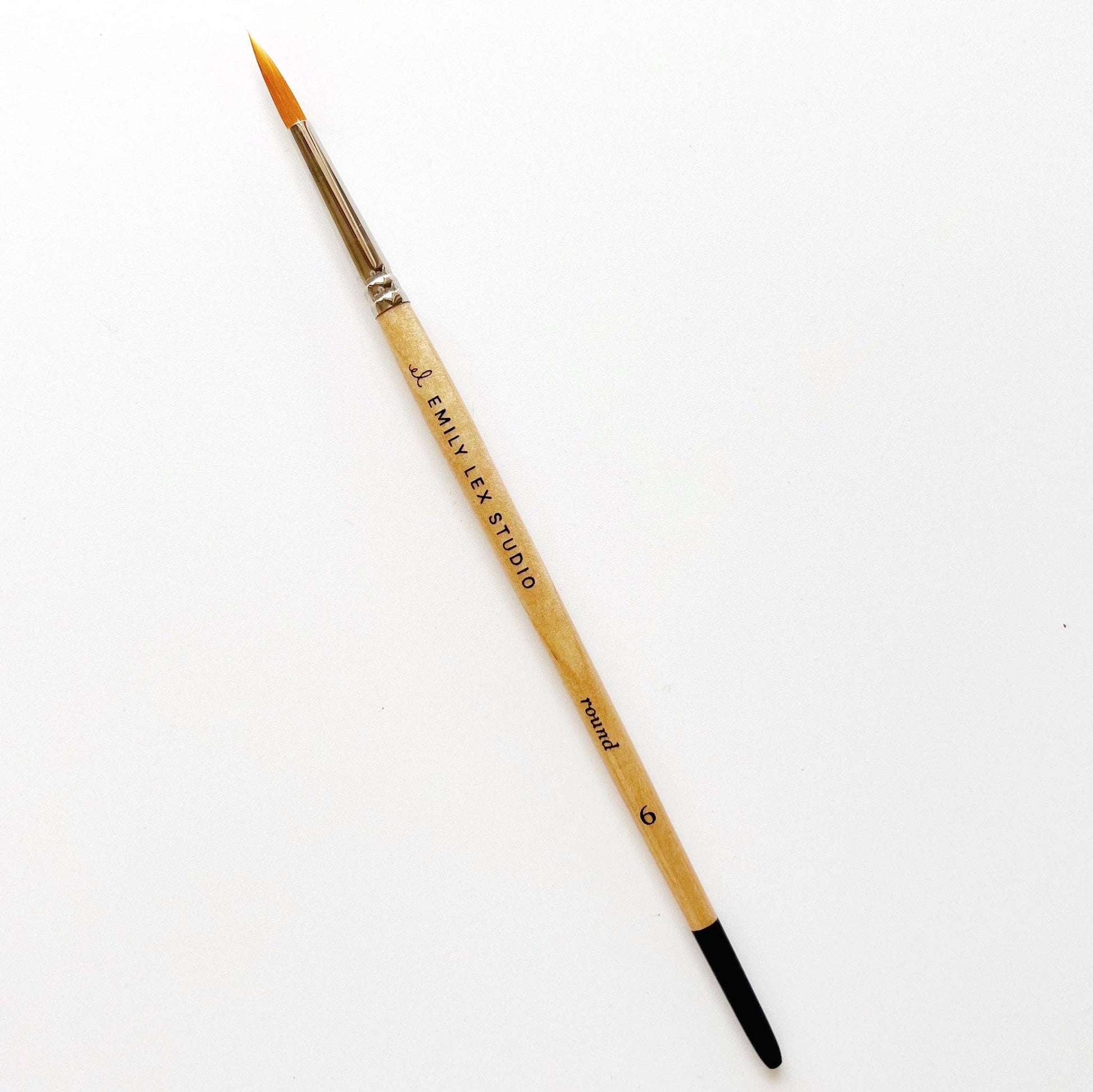 A watercolor paintbrush with golden synthetic taklon bristles, seamless aluminum ferrules, and lacquered wood handles, from emily lex studio, size 6, great for the bulk of the paintings.