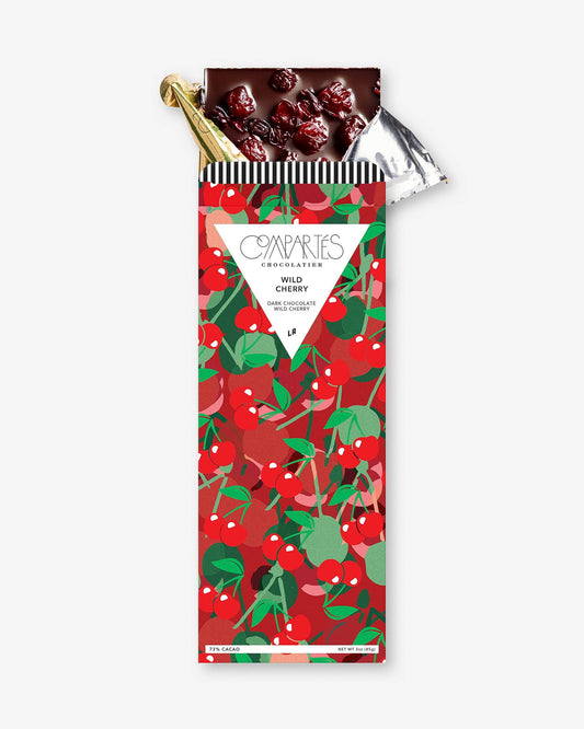 A gourmet dark chocolate bar with visible pieces of cherries embedded in it, wrapped in a colorful packaging with cherries.